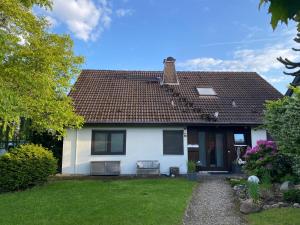 a white house with a brown roof at Auszeitwohnung in Lage