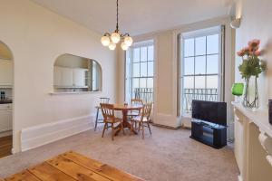 a kitchen and dining room with a table and a tv at Coastal charm in Herne Bay +11 photos