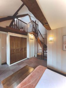 a bedroom with a bed and a wooden staircase at Hôtel des Cymaises in Semur-en-Auxois