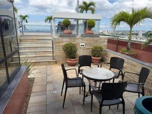 a patio with a table and chairs and the ocean at Flat no Hotel Millenium Manaus in Manaus