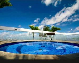 a large blue swimming pool on top of a building at Flat no Hotel Millenium Manaus in Manaus