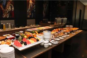 a buffet with many different types of food on a table at Flat no Hotel Millenium Manaus in Manaus
