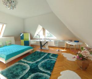 a bedroom with a bed and a desk in a attic at Villa Panorama in Biatorbágy