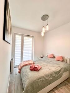 a bedroom with a large bed with pink pillows on it at Apartament Tosia in Chełm