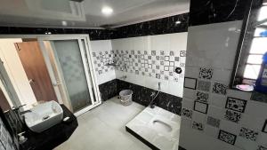 a black and white bathroom with a sink and a toilet at Kodai Mistview Cottage in Kodaikānāl