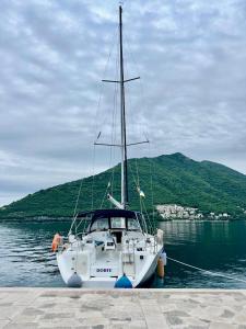 a white boat is docked in the water at Dorfe Kotor Muo in Tivat