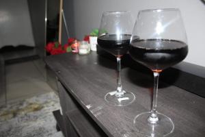 two glasses of red wine sitting on a counter at Penthouse in Bloemfontein