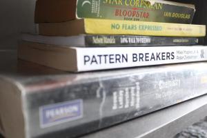 a stack of books sitting on a shelf at Penthouse in Bloemfontein