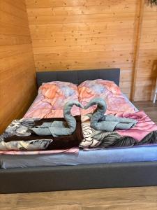 two swans laying on a bed in a room at Domek Letniskowy in Iława