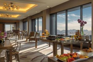 a dining room with tables filled with food and windows at Grand Hyatt Denver in Denver