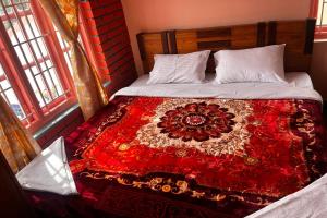 a bedroom with a bed with a red blanket on it at Kodai Mistview Cottage in Kodaikānāl