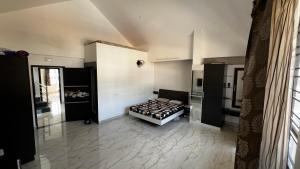 a bedroom with a bed in the middle of a room at Kodai Mistview Cottage in Kodaikānāl
