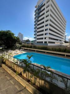 a large swimming pool in front of a tall building at Summit Flat São José dos Campos in São José dos Campos
