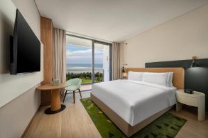 a hotel room with a bed and a tv at Holiday Inn Beihai Silver Beach in Beihai +47 photos