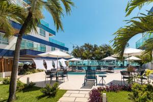 a view of the pool at the resort with tables and umbrellas at Coral Plaza Apart Hotel in Natal