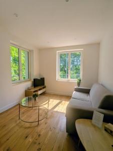 a living room with a couch and a glass table at Air-conditioned apartment - two bedrooms in Vichy