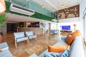 a living room with a couch and two chairs at Coral Plaza Apart Hotel in Natal
