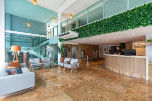 a man standing at a counter in a lobby at Coral Plaza Apart Hotel in Natal +138 photos