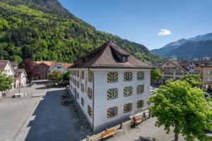an old building in a town with mountains in the background at Interalps - AlpsView Premium Apartments Altdorf - Free Parking - AC in Altdorf