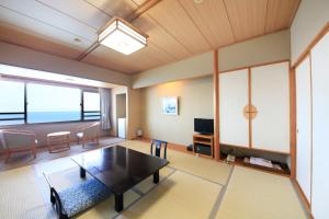 sala de estar con mesa y sofá en Heiseikan Shiosaitei en Hakodate