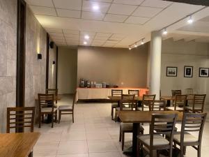 a restaurant with wooden tables and chairs and a counter at Hotel Los Condores in Uspallata