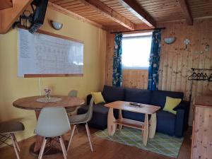 a living room with a table and a couch at Domki Obok Ruin in Trzęsacz