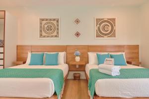 two beds in a room with blue and white at Hotel Fusión in Puerto Escondido +90 photos