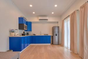 a kitchen with blue cabinets and a refrigerator at Hotel Fusión in Puerto Escondido