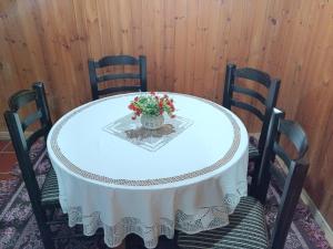 a white table with chairs and a vase with flowers on it at Altin Prendi B&B in Divjakë +5 photos