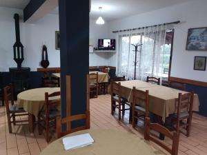 a dining room with tables and chairs and a tv at Altin Prendi B&B in Divjakë