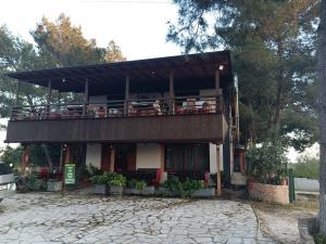 a building with a balcony on top of it at Altin Prendi B&B in Divjakë