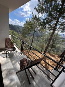 two benches sitting on a balcony with a view at Casa Madera Completa in Zacatlán