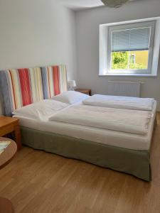 a large bed in a bedroom with a window at Karawanken Nest in Feistritz im Rosental