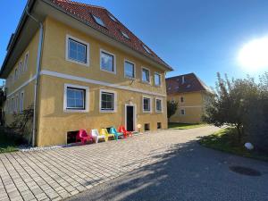 a house with colorful chairs sitting outside of it at Karawanken Nest in Feistritz im Rosental