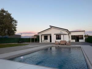 a swimming pool in front of a house at Holliday Villa in Tirana