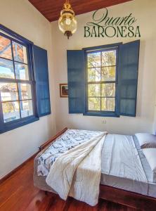 a bed in a room with a sign on the wall at Refúgio Casarão in Passa Quatro