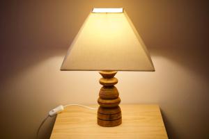 a wooden lamp with a shade on a table at BE LOST - Guest House in Pedra Do Ouro