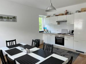 a kitchen with a table and a kitchen with white cabinets at Karawanken Glück in Feistritz im Rosental