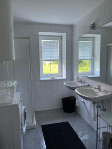 a white bathroom with two sinks and two windows at Karawanken Glück in Feistritz im Rosental +46 photos