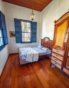 a bedroom with a bed and a dresser at Refúgio Casarão in Passa Quatro +25 photos