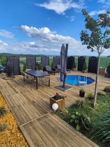 a deck with a table and chairs and a pool at Domek Dolina Żurawia in Borzynowo