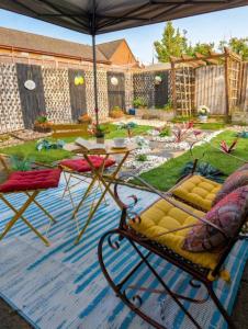 a patio with a table and chairs under an umbrella at Unique By Monique Kingsholm Bungalow Parking in Gloucester