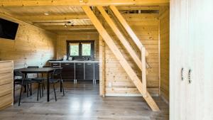 a kitchen and dining room in a log cabin at "OhMazury" ogród i winnica in Giżycko