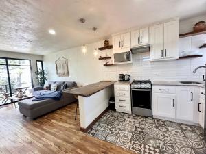 a kitchen with white cabinets and a table and a couch at Casa Madera Completa in Zacatlán
