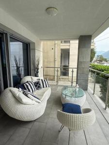 a balcony with two chairs and a glass table at Luxury Waterfront Apartment in Boka Bay, Stollywood in Donji Stoliv