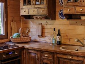 a kitchen with wooden cabinets and a counter with wine glasses at Domek Hortensja in Zawady