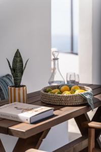 a bowl of fruit sitting on a wooden table at Blu Dot Tinos in Dhió Kkhoriá