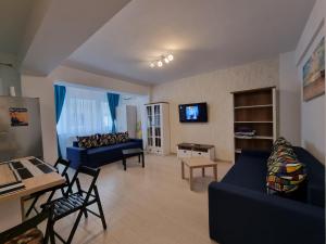 a living room with blue couches and a tv at Promenada 1-4 in Mamaia Sat/Năvodari