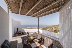 a balcony with a table and a view of the ocean at Blu Dot Tinos in Dhió Kkhoriá