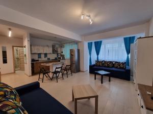 a living room with a blue couch and a kitchen at Promenada 1-4 in Mamaia Sat/Năvodari